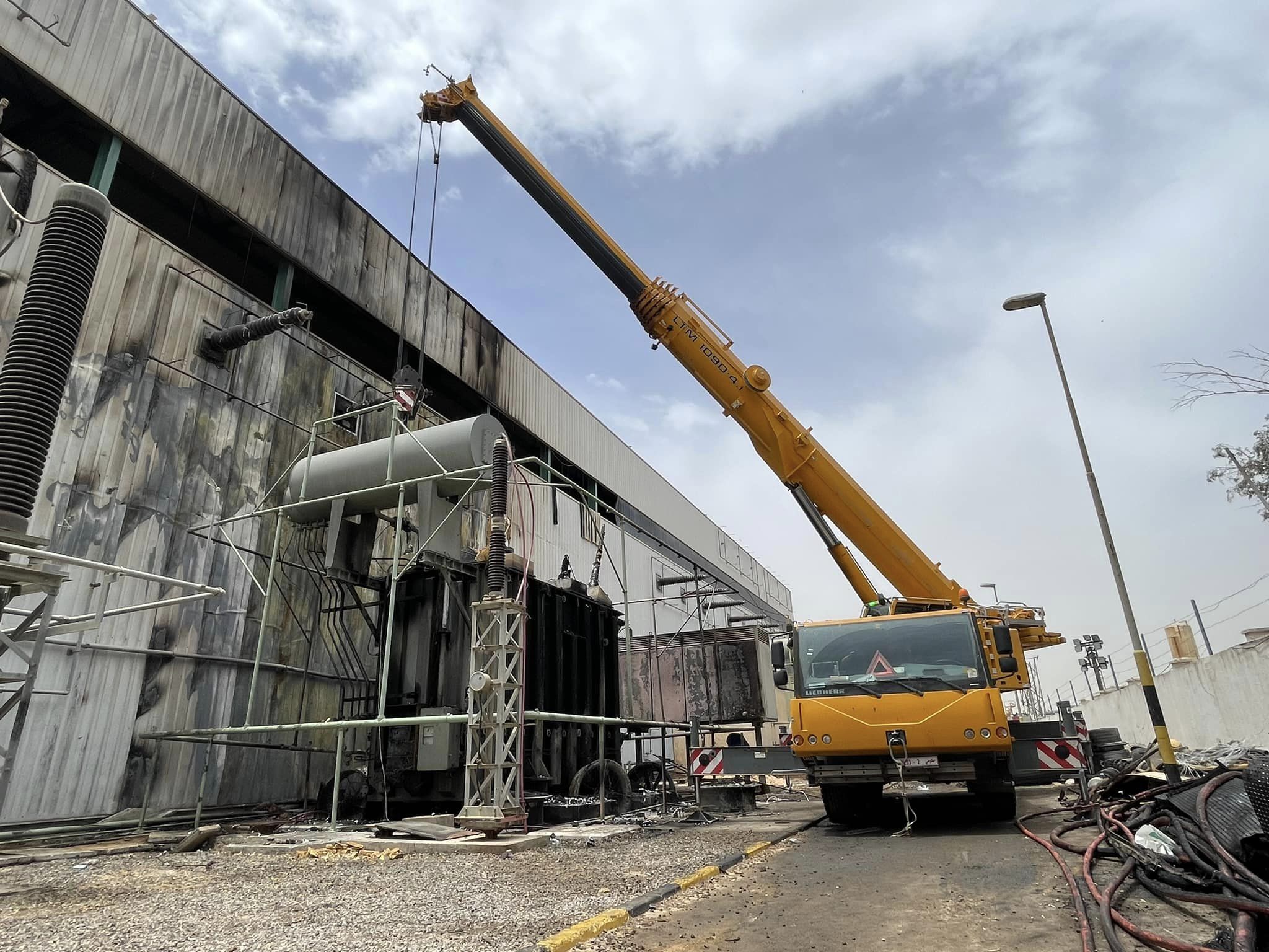 مهندسو وفنيو الكهرباء يشرعون بعملية فك المحول المحترق بمحطة الهضبة وتركيب بديلًا عنه